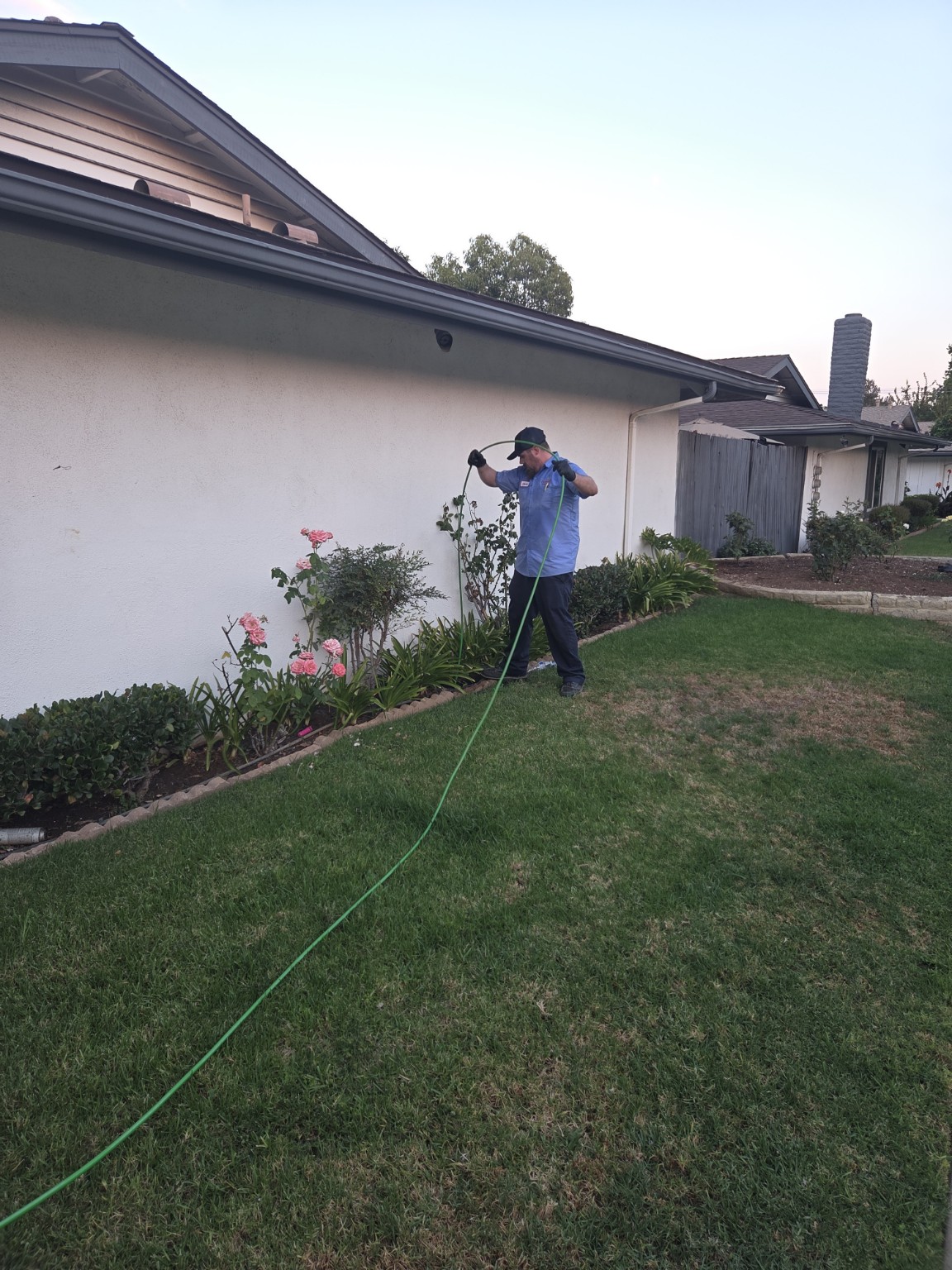 Overall Plumbing Co. technician servicing an exterior drain line